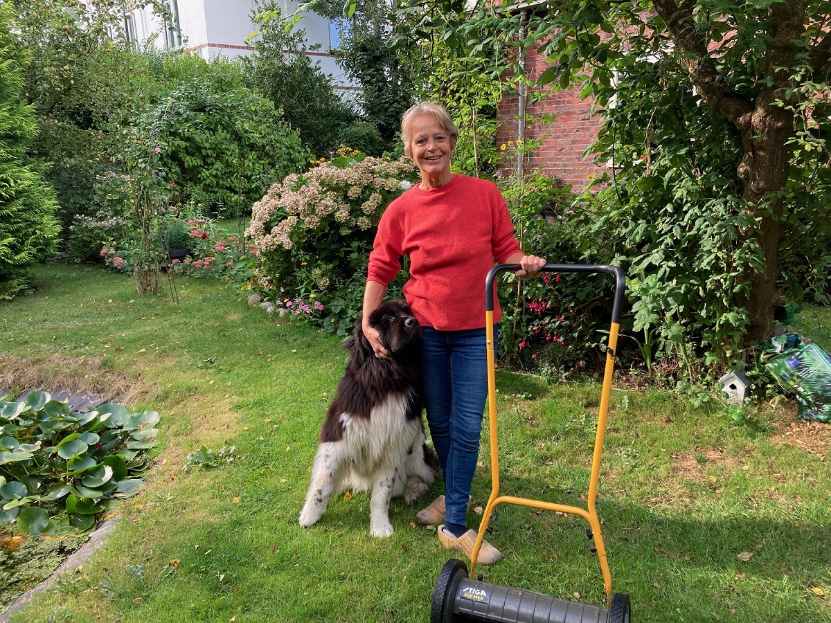 Foto Yvonne van Mastrigt in tuin met hond en grasmaaier
